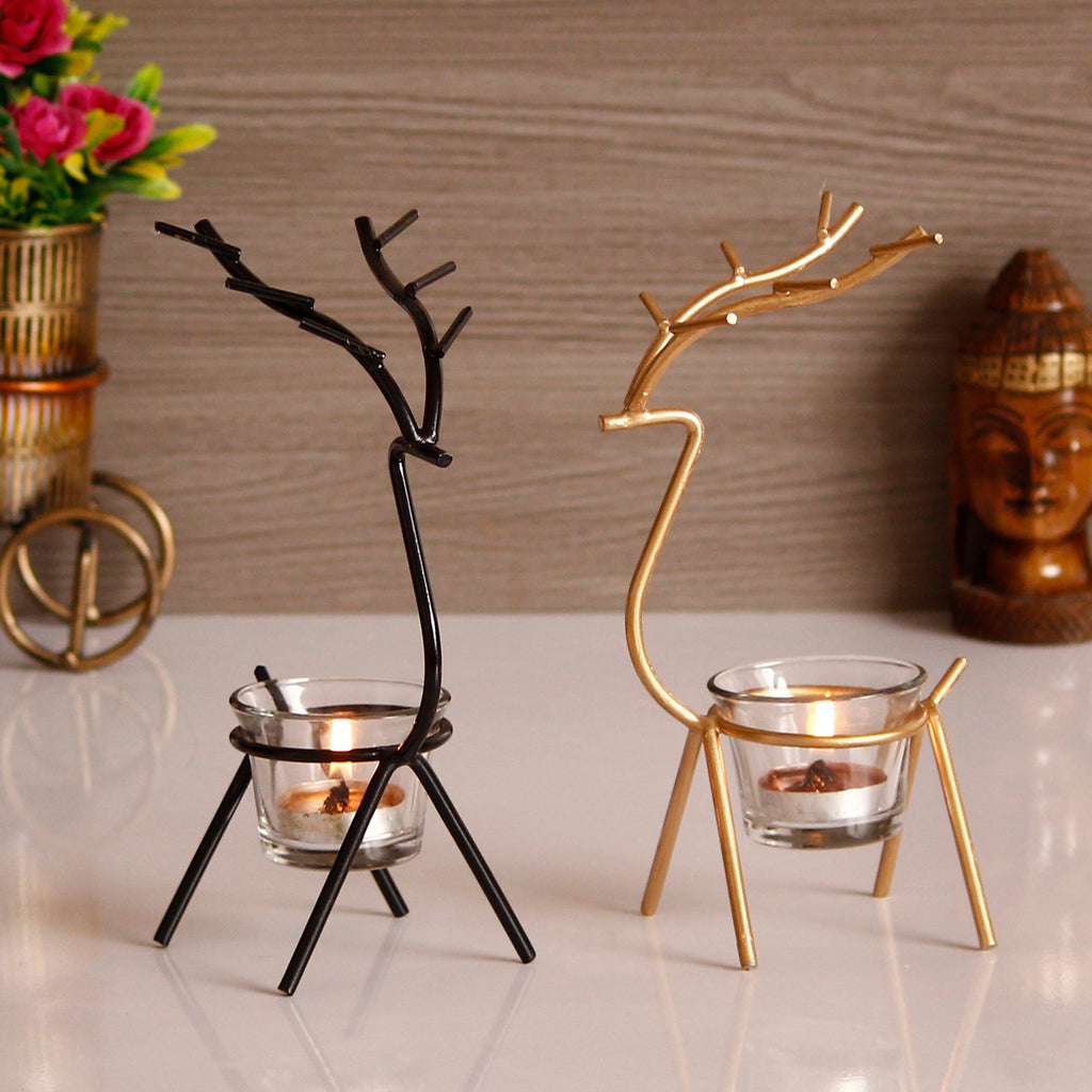 Two decorative candle holders shaped like deer in black and gold .